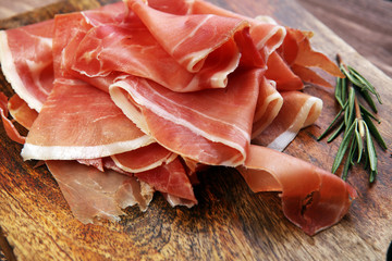 Italian prosciutto crudo or jamon with rosemary. Raw ham. - obrazy, fototapety, plakaty