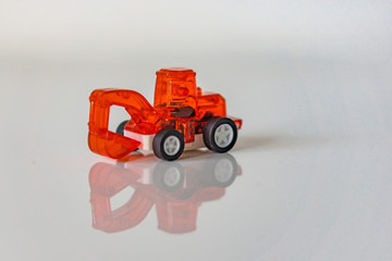 Toy red loader on white backgraund. Concept motor skills.