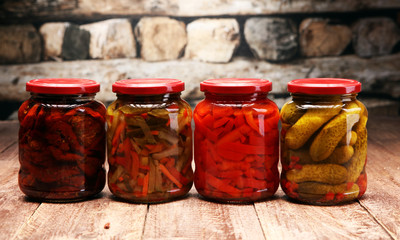 Jar with variety of pickled vegetables. Carrots, field garlic, parsley in glas. Preserved food. Fermented preserved vegetarian food concept. Canned food