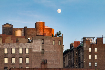 Full moon rising above old brick buildings around Union Square Park in Manhattan, New York City