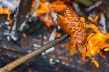 Summer roasting of sausages on fire