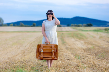 Portrait of senior woman with travel suitcase