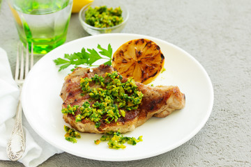 Pork cutlet on a bone with gremolat sauce.