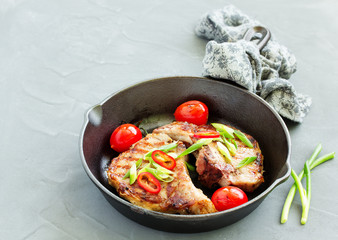 Pork cutlet on a bone with baked vegetables.