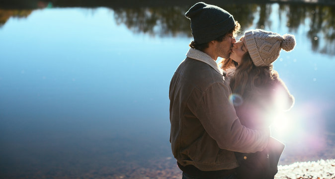 Couple in love kissing on a sunny autumn day near a lake.
