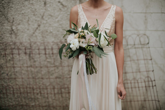 Bohemian indie bride in simple sparkle top wedding dress and feminine pastel bouquet with ribbon