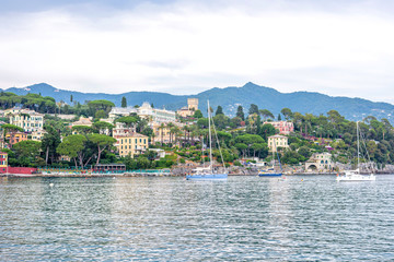 Fototapeta na wymiar Cruising boats with people near port of Santa Margherita Ligure in Italy. Tusky day. Cinque Terre