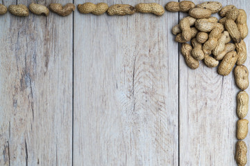 Fototapeta premium Peanuts on wood textured surface