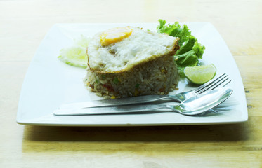 Crab Fried Rice with Fried Egg on white dish on wooden table backgrounds