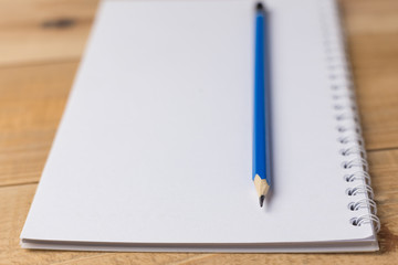Blank notebook with pencil on wooden table, business concept