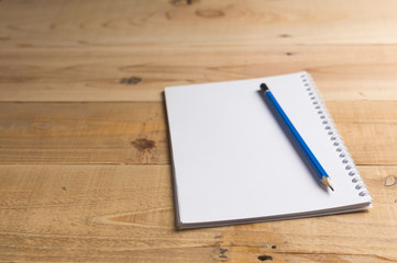 Blank notebook with pencil on wooden table, business concept