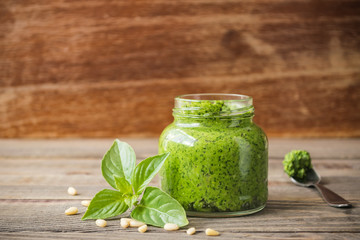 The Basil pesto and pine nuts in a glass jar.
