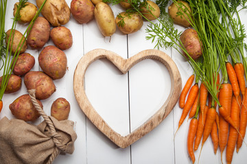 Potatoes, carrots and heart on a white background