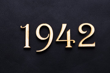 1942. One thousand nine hundred and forty-two. Wooden figures on a background of black leather
