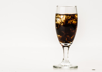 Dark brown food coloring diffuse in water inside wine glass with empty copyspace area for slogan or advertising text message, over isolated grey background. 