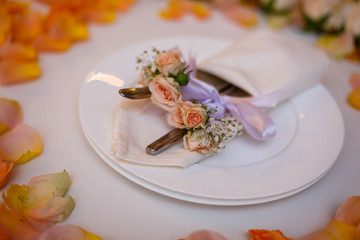 White table and orange rose petals