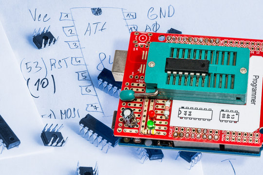 Programmer for controllers. Programmer for AVR chips with a sketch in the background.