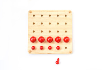 Red pegs board, wood beads on white background