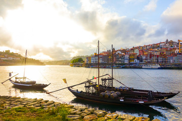 The colorful old town of Porto with traditional Rabelo boats on the Douro river in the late afternoon