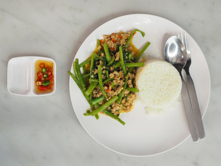 Top view Thai local stir fried morning glory green stem with minced pork on white rice, top view