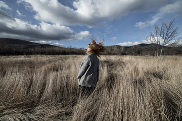 Woman posing in dried mountains field 