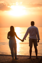 A married couple meet a romantic sunset by the lake, lovers hold hands by the river or lake, a man and a woman are on the nature on a summer day