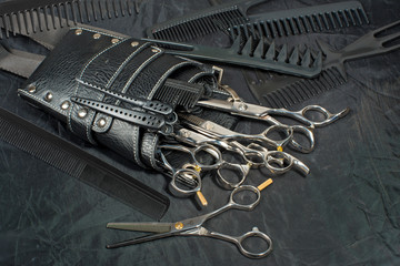 A leather bag of a hairdresser with scissors.
