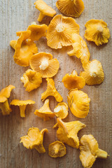 Mushrooms chanterelles lie on a wooden table. Healthy food. Closeup, selective focus. Vertical photography.