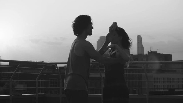 Silhouettes of young couple dancing on sunset