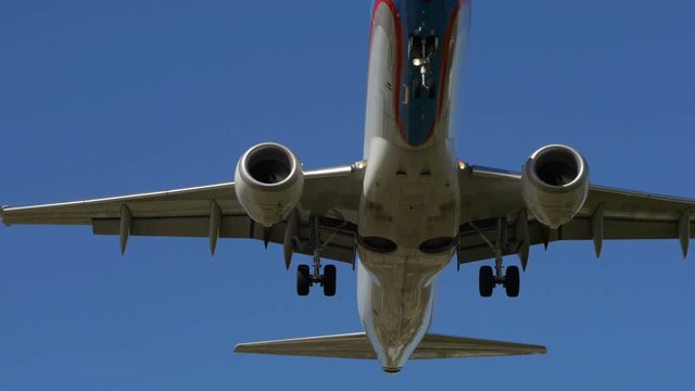 Plane passing by and about to Land. Over blue sky. day.