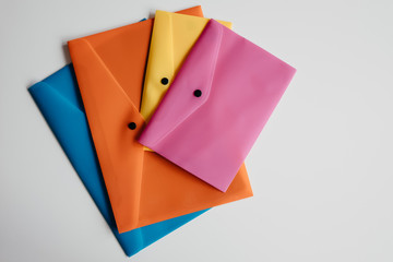 .Composition of four plastic envelopes of different colors on a white background. Back to school photography