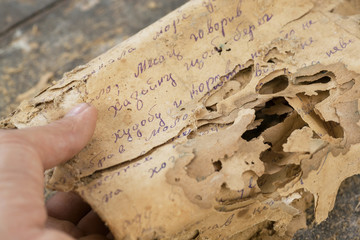 Reading of pages of the documents, letters of past centuries or paper manuscripts in unknown language, spoiled by time