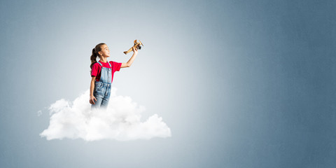 Concept of careless happy childhood with girl dreaming to become pilot