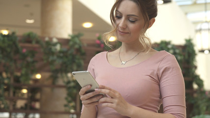 Attractive young woman uses a smartphone