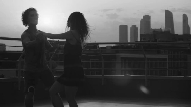Silhouettes of young couple dancing on sunset
