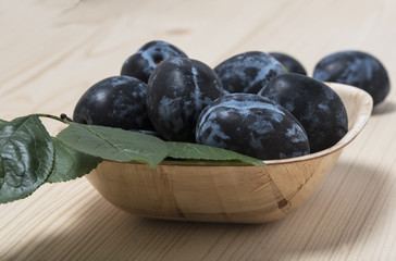 Ripe plums with green leaves