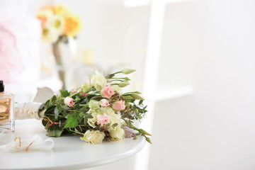 Composition with wedding rings and bouquet of flowers on table