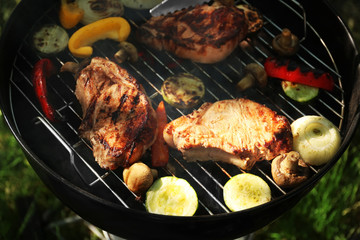 Tasty steaks and vegetables on barbecue grill