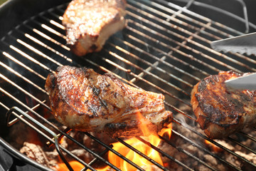 Tasty steaks on barbecue grill, close up
