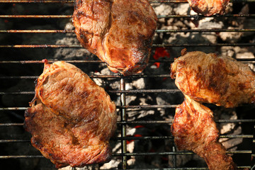 Tasty steaks on barbecue grill, close up