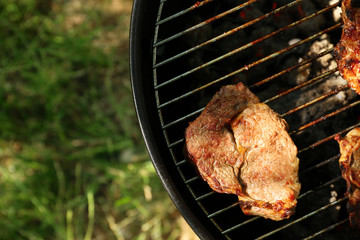 Tasty steak on barbecue grill outdoors, close up