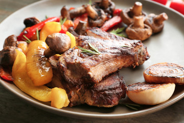 Plate with tasty grilled steak and vegetables on table, close up