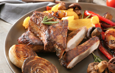 Plate with tasty grilled steak and vegetables on table, close up