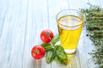 Glass with cooking oil on wooden table