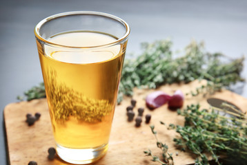 Glass with cooking oil on wooden board