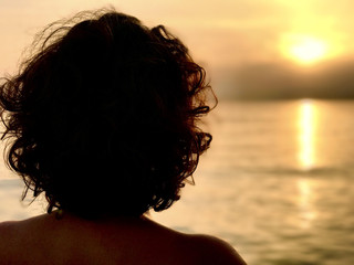 Beautiful young woman in bikini looking ocean 