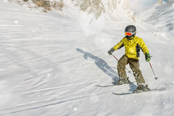 The boy on skis in mountains