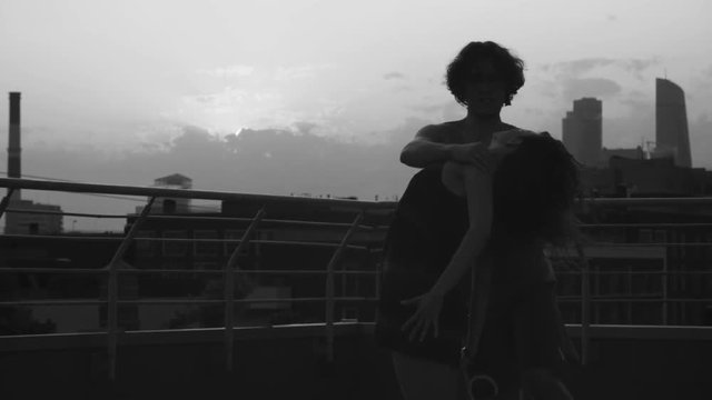 Silhouettes of young couple dancing on sunset