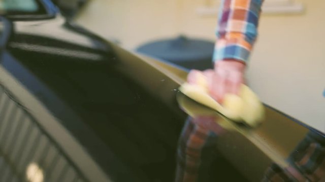 Young woman washing her car