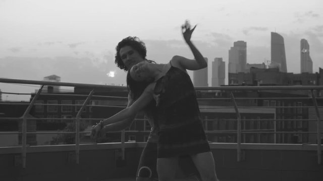 Silhouettes of young couple dancing on sunset